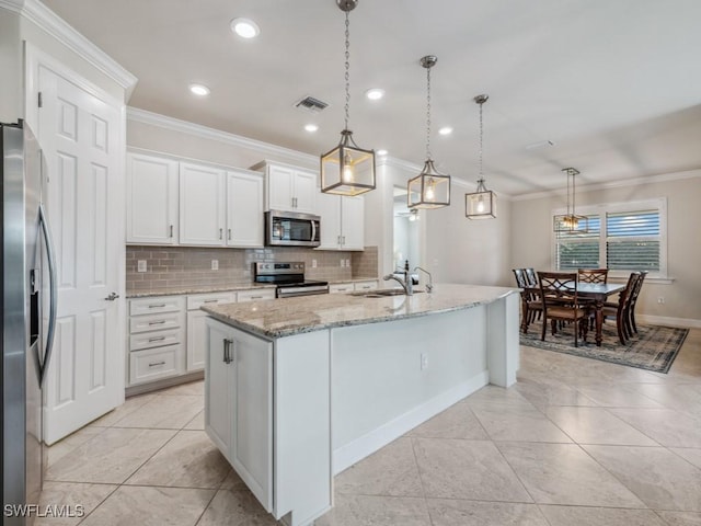 17183 Ashford Ter, Fort Myers, FL 33967 - kitchen with hanging light fixtures, appliances with stainless steel finishes, white cabinetry, and a kitchen island with sink