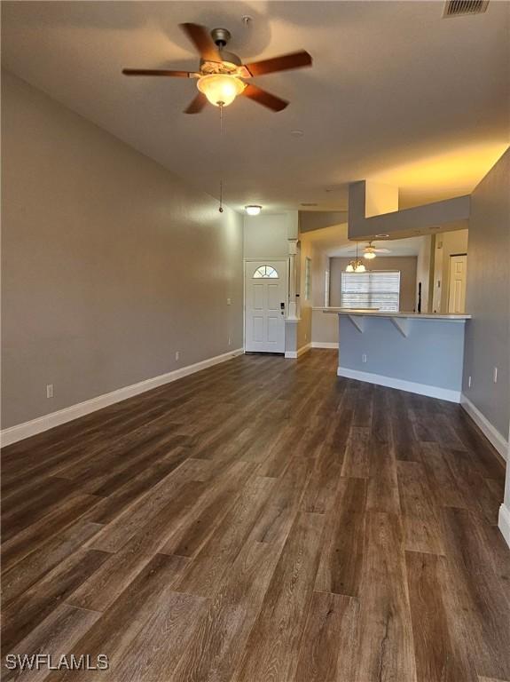 23861 Costa Del Sol Rd Unit 203, Estero, FL 34135 - unfurnished living room with dark wood-type flooring, ceiling fan, and baseboards