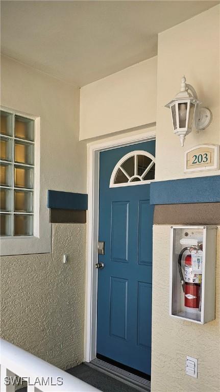 23861 Costa Del Sol Rd Unit 203, Estero, FL 34135 - view of exterior entry featuring stucco siding