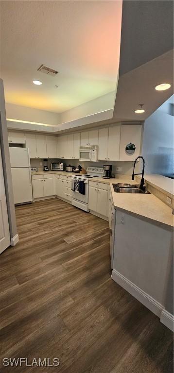 23861 Costa Del Sol Rd Unit 203, Estero, FL 34135 - kitchen featuring white appliances, a sink, dark wood-style flooring, light countertops, and white cabinets