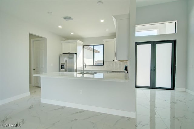 kitchen featuring tasteful backsplash, white cabinetry, sink, stainless steel refrigerator with ice dispenser, and french doors