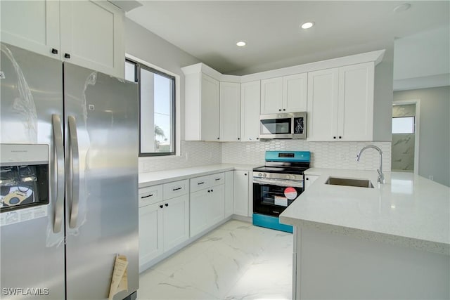 kitchen featuring sink, a wealth of natural light, stainless steel appliances, and white cabinets