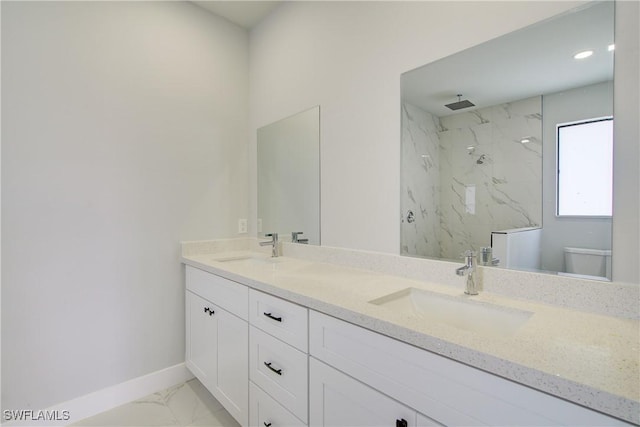 bathroom featuring vanity, toilet, and tiled shower