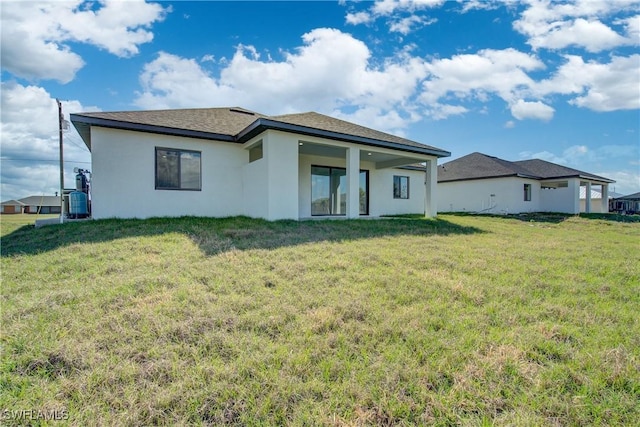 rear view of house featuring a yard