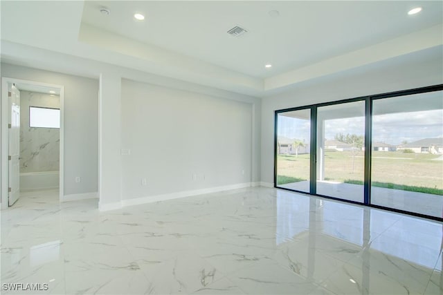 spare room with a raised ceiling