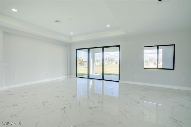 spare room with a raised ceiling