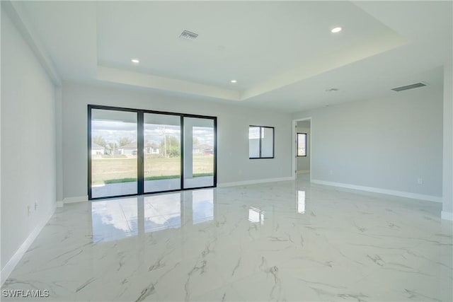 unfurnished room with a tray ceiling