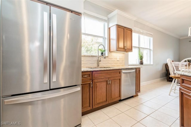 kitchen featuring appliances with stainless steel finishes, tasteful backsplash, light tile patterned flooring, ornamental molding, and sink