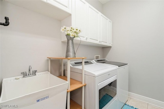 laundry room with cabinets, washer and dryer, sink, and light tile patterned floors