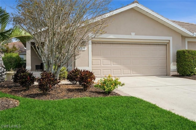2291 Granby Dr, Lehigh Acres, FL 33973 - view of front of house featuring an attached garage, stucco siding, driveway, and a front yard