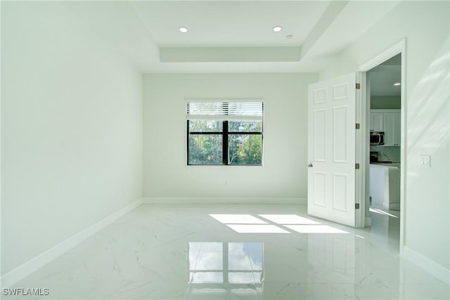 unfurnished room with a tray ceiling