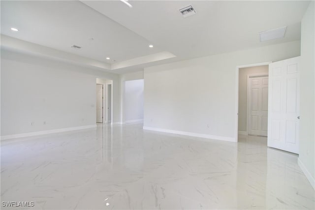 unfurnished room with a tray ceiling