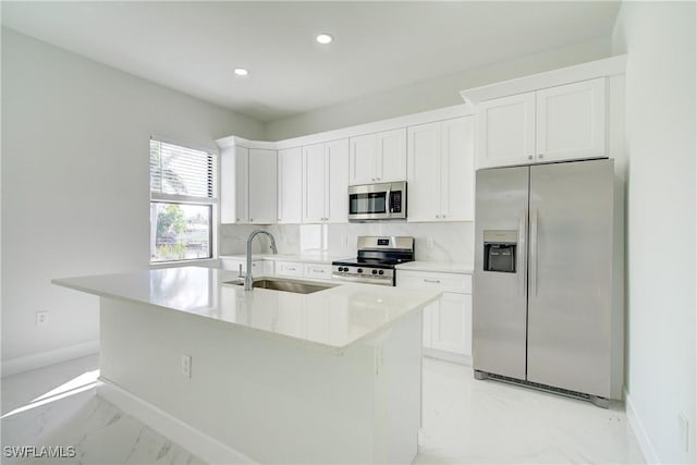 kitchen with white cabinetry, appliances with stainless steel finishes, a kitchen island with sink, and sink