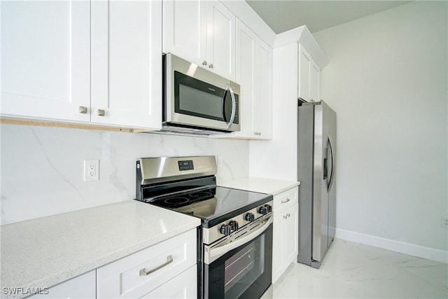 kitchen with decorative backsplash, light stone countertops, white cabinets, and appliances with stainless steel finishes