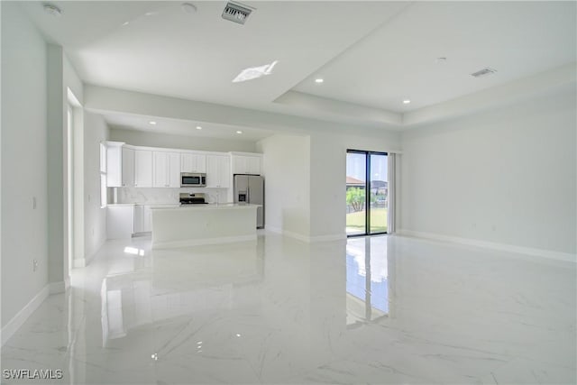 unfurnished living room featuring a raised ceiling