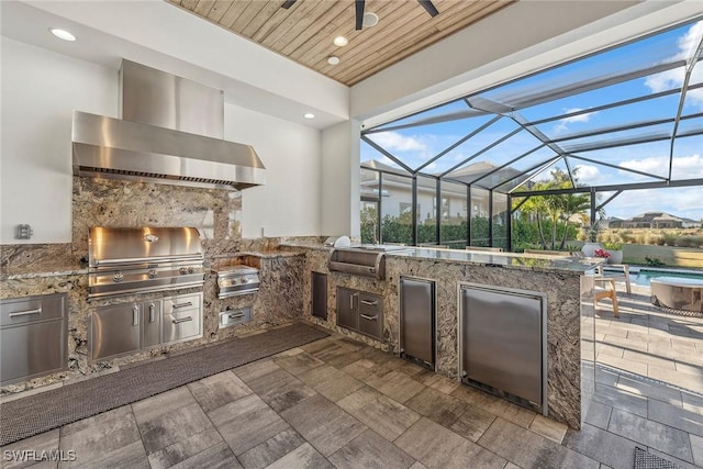 view of patio with exterior kitchen, glass enclosure, an outdoor pool, and grilling area