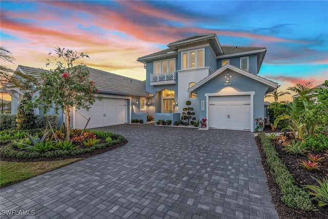 view of front of property with decorative driveway, a balcony, and stucco siding