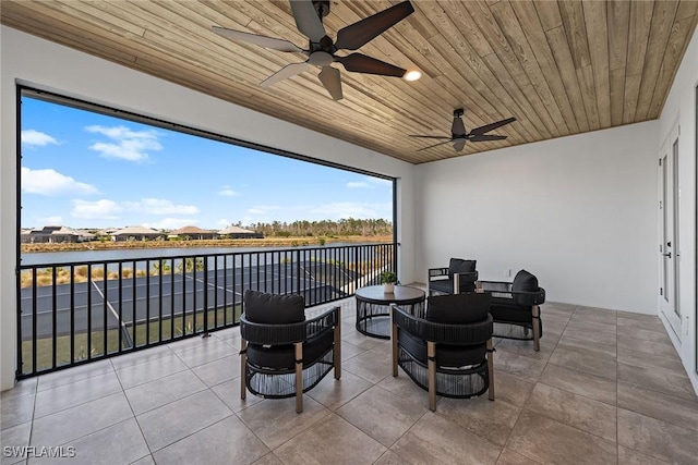 view of patio with ceiling fan, a water view, and an outdoor living space