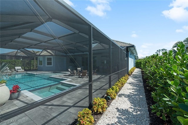 pool with glass enclosure and a patio area