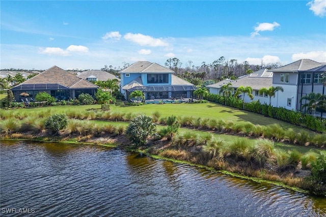 back of house with a water view and a yard