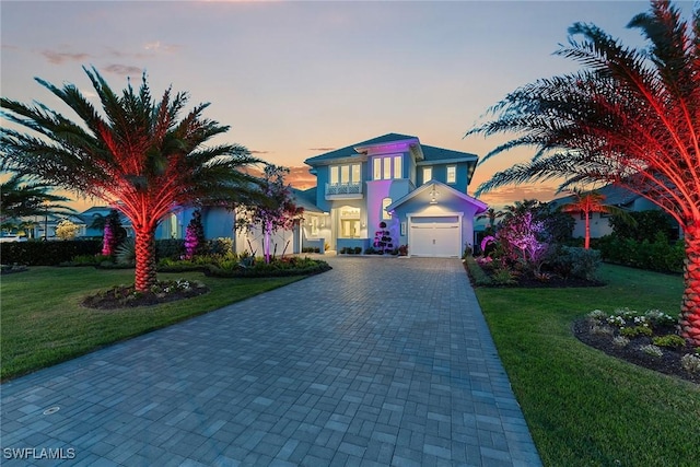 view of front of house featuring a front lawn, decorative driveway, and stucco siding