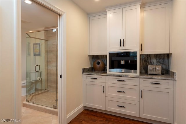 bar with decorative backsplash, oven, baseboards, dark wood-type flooring, and recessed lighting