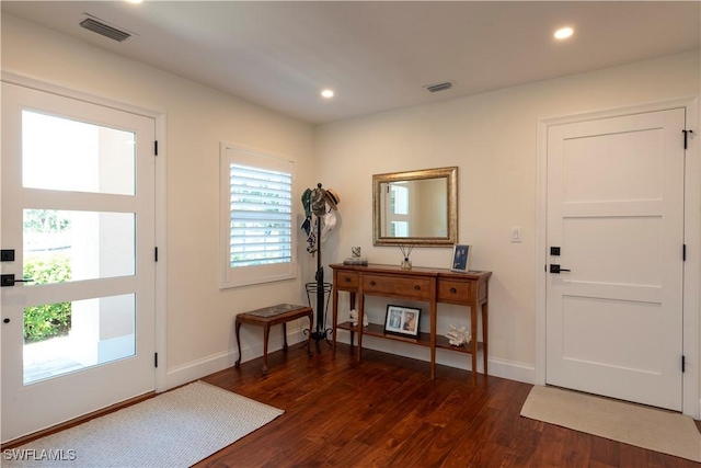 entryway with baseboards, visible vents, dark wood-type flooring, and recessed lighting