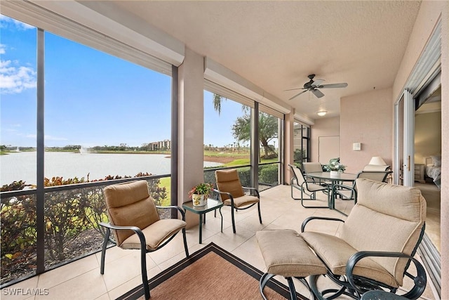 sunroom / solarium with a water view and ceiling fan