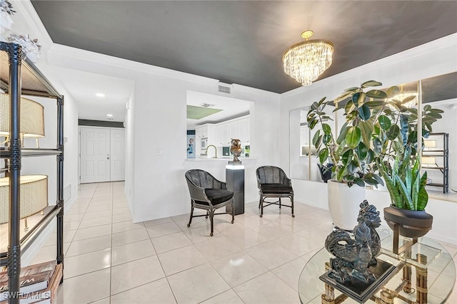 living area featuring an inviting chandelier, crown molding, sink, and light tile patterned floors