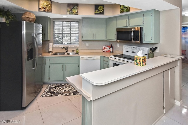 4 Park Lane Cir, Lehigh Acres, FL 33936 - kitchen with stainless steel appliances, a peninsula, green cabinetry, light tile patterned floors, and light countertops