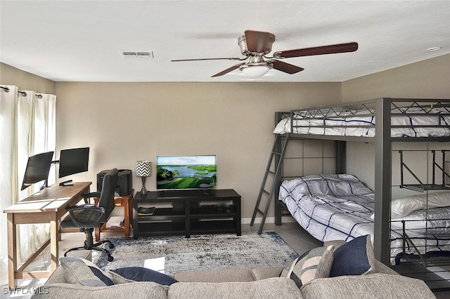 tiled bedroom with baseboards, visible vents, and a ceiling fan