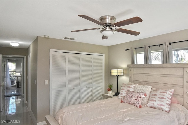 bedroom with a ceiling fan, multiple windows, visible vents, and a closet