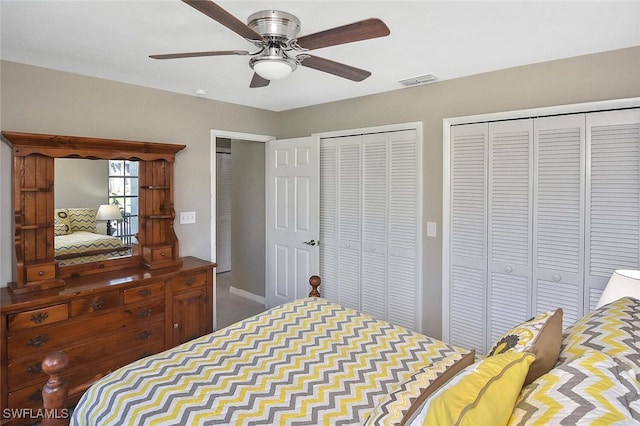 bedroom featuring a ceiling fan, visible vents, and multiple closets