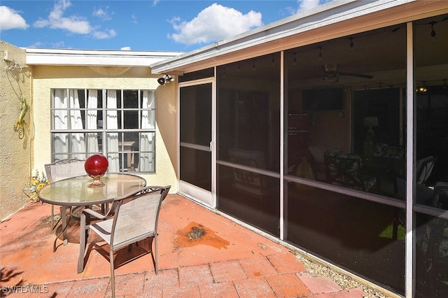 view of patio with outdoor dining space and a sunroom