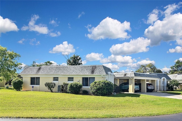 view of front of property featuring driveway, mansard roof, cooling unit, a front lawn, and a carport