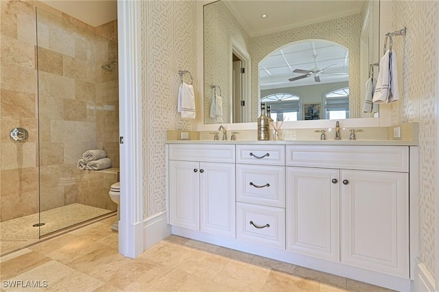 full bath with wallpapered walls, tiled shower, a ceiling fan, and a sink