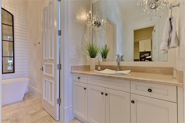 full bath with a soaking tub, an inviting chandelier, and vanity