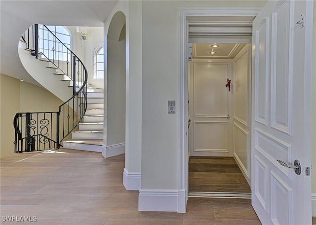 104 Bonaire Ln, Bonita Springs, FL 34134 - interior space featuring baseboards, arched walkways, wood finished floors, and stairway