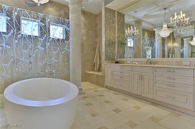 bathroom with a wealth of natural light, a soaking tub, vanity, and ornate columns