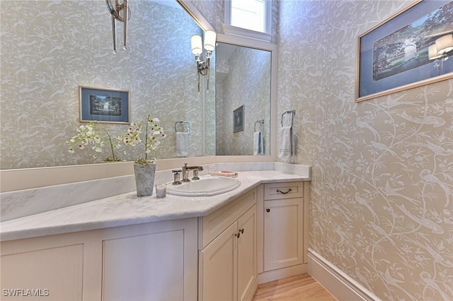 bathroom featuring wallpapered walls, vanity, and wood finished floors