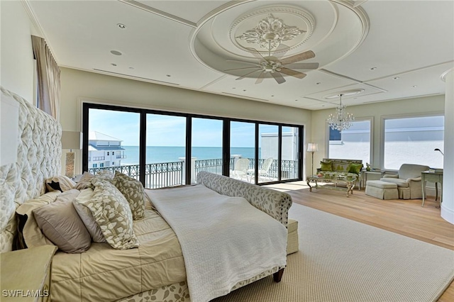 104 Bonaire Ln, Bonita Springs, FL 34134 - bedroom featuring access to exterior, wood finished floors, an inviting chandelier, and multiple windows