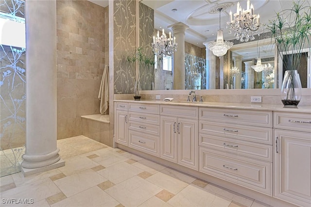 full bath with a chandelier, a tile shower, vanity, and ornate columns