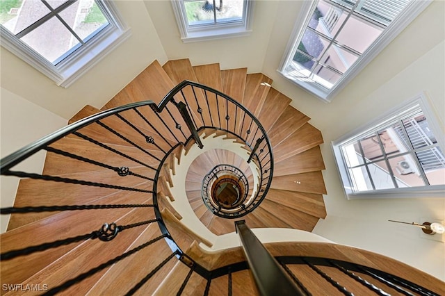 staircase featuring a skylight and a towering ceiling