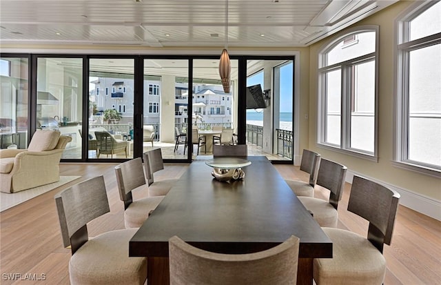 dining space with plenty of natural light, wood finished floors, and baseboards