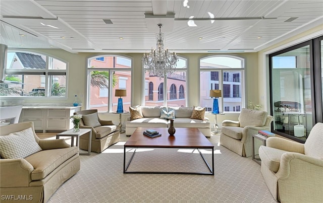 sunroom featuring a notable chandelier and wood ceiling