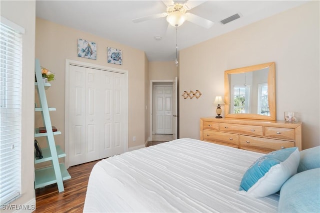 bedroom featuring dark wood-type flooring, a closet, and ceiling fan