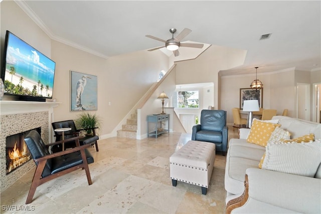 living room with crown molding, ceiling fan, and a fireplace