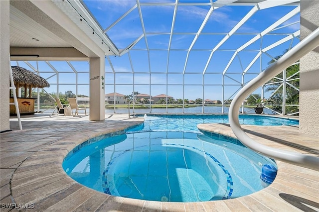 pool featuring glass enclosure and a patio area