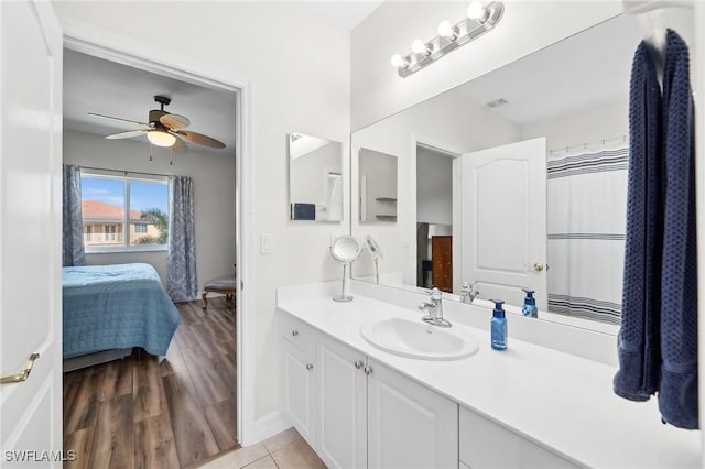 ensuite bathroom with visible vents, ensuite bathroom, wood finished floors, ceiling fan, and vanity