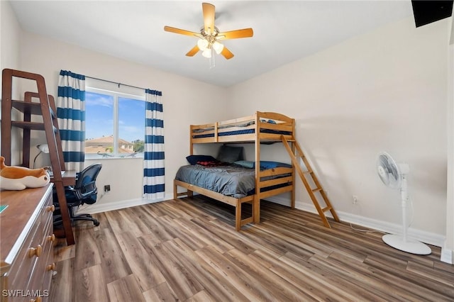 bedroom featuring wood finished floors, baseboards, and ceiling fan